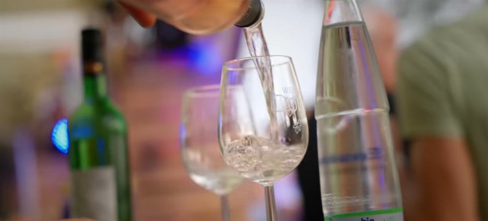 Kellner schenkt Wein und Wasser ein
